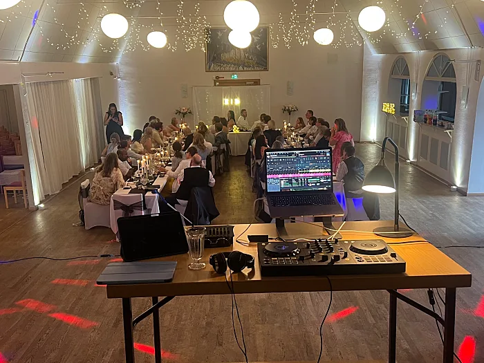 DJ-bord i en festlokal med dansgolv och middagsgäster